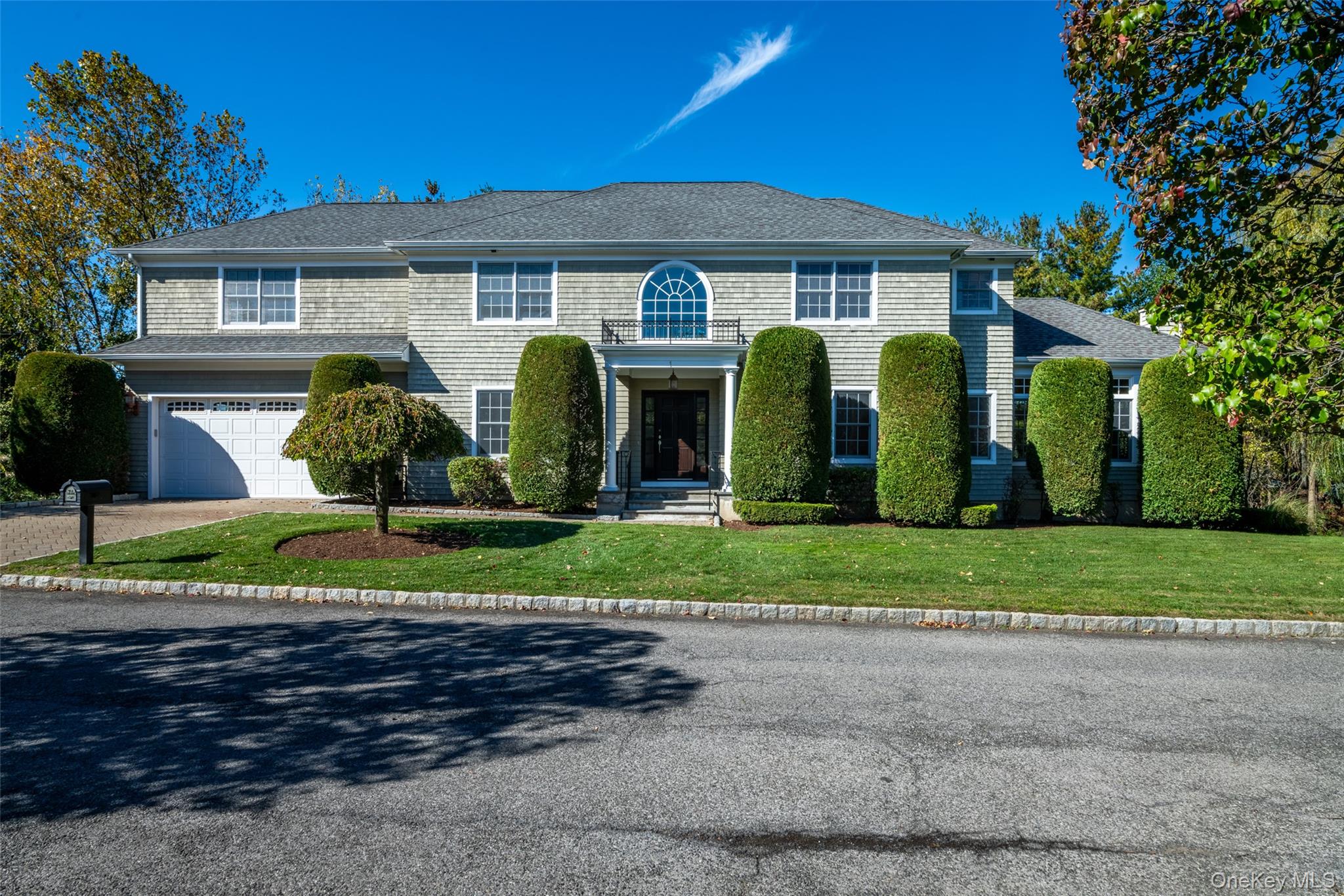 a front view of a house with a garden and plants