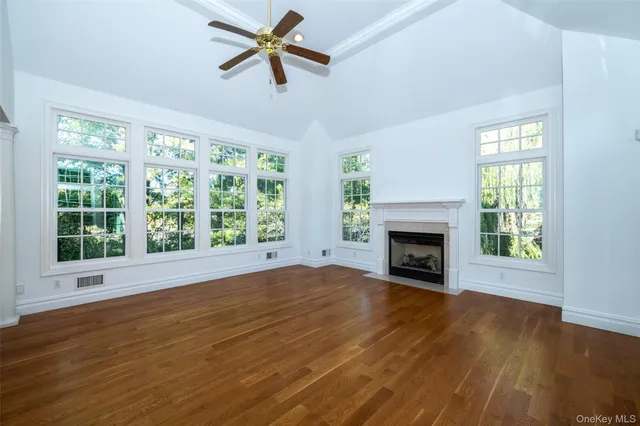 a view of empty room with wooden floor fireplace and windows