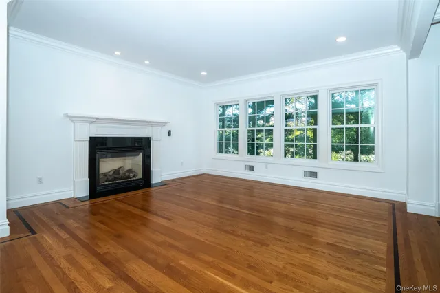 an empty room with windows and fireplace