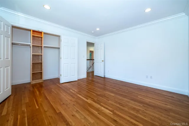 a view of an empty room with closet and a window