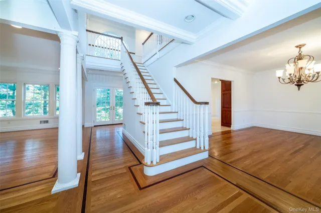 a view of a livingroom with wooden floor and stairs