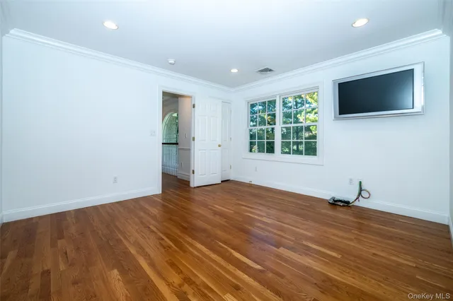 a view of a livingroom with wooden floor and windows
