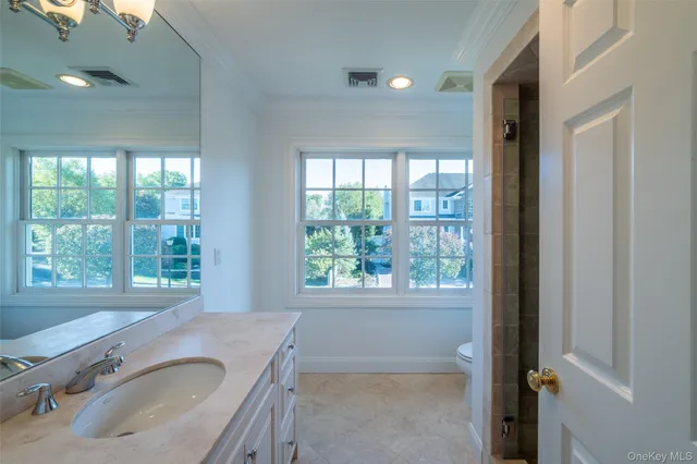 a bathroom with a granite countertop sink and a window