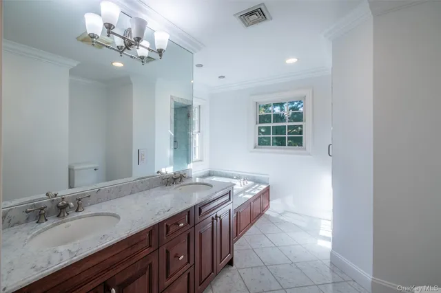a spacious bathroom with a granite countertop sink a large mirror and a bathtub