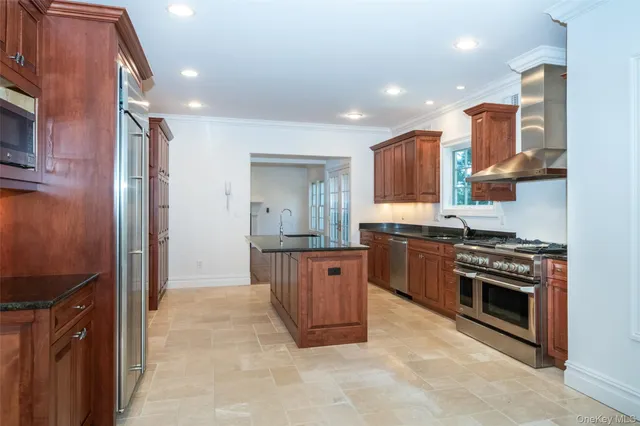 a large kitchen with stainless steel appliances granite countertop a stove a sink and a refrigerator
