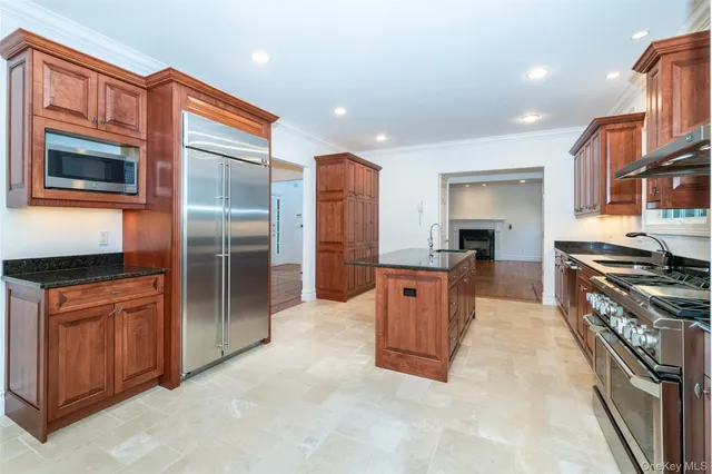 a large kitchen with stainless steel appliances granite countertop a stove refrigerator and a kitchen island