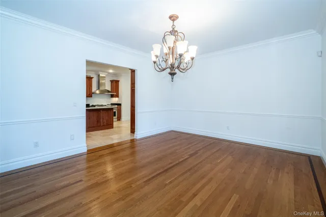 wooden floor in an empty room with a chandelier