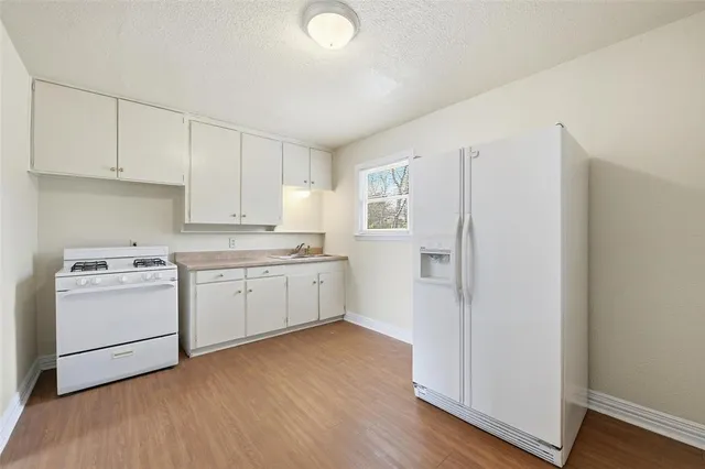 a kitchen with white cabinets and white appliances