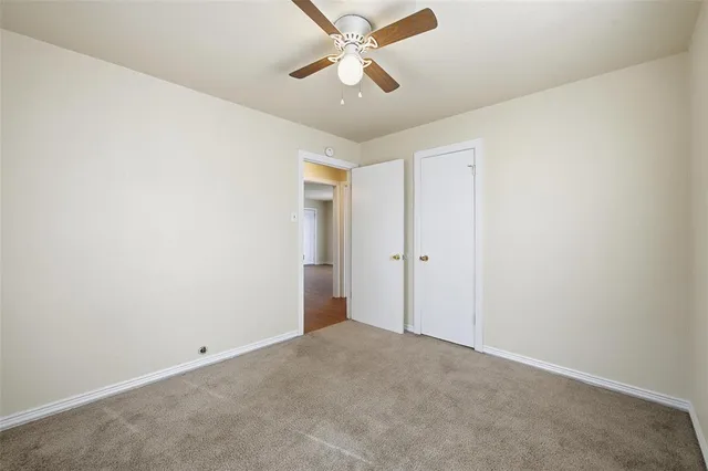 an empty room with chandelier fan