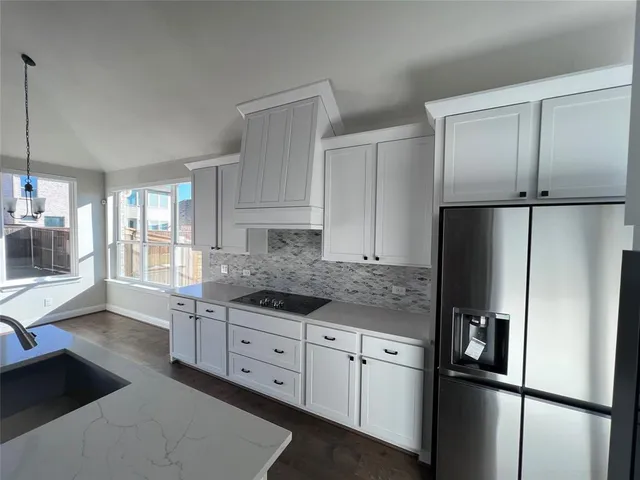 a kitchen with stainless steel appliances granite countertop a refrigerator and a stove