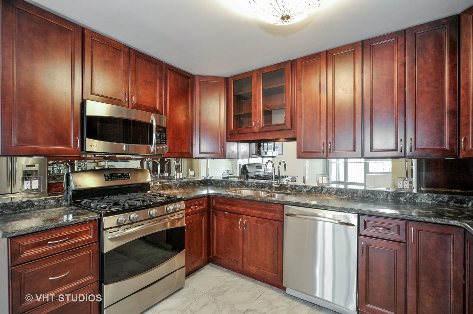 400 East Randolph Street, Unit 1924 Chicago, IL 60601 - Photo 4 of 18 a kitchen with granite countertop stainless steel appliances wooden cabinets a stove top oven a sink and dishwasher