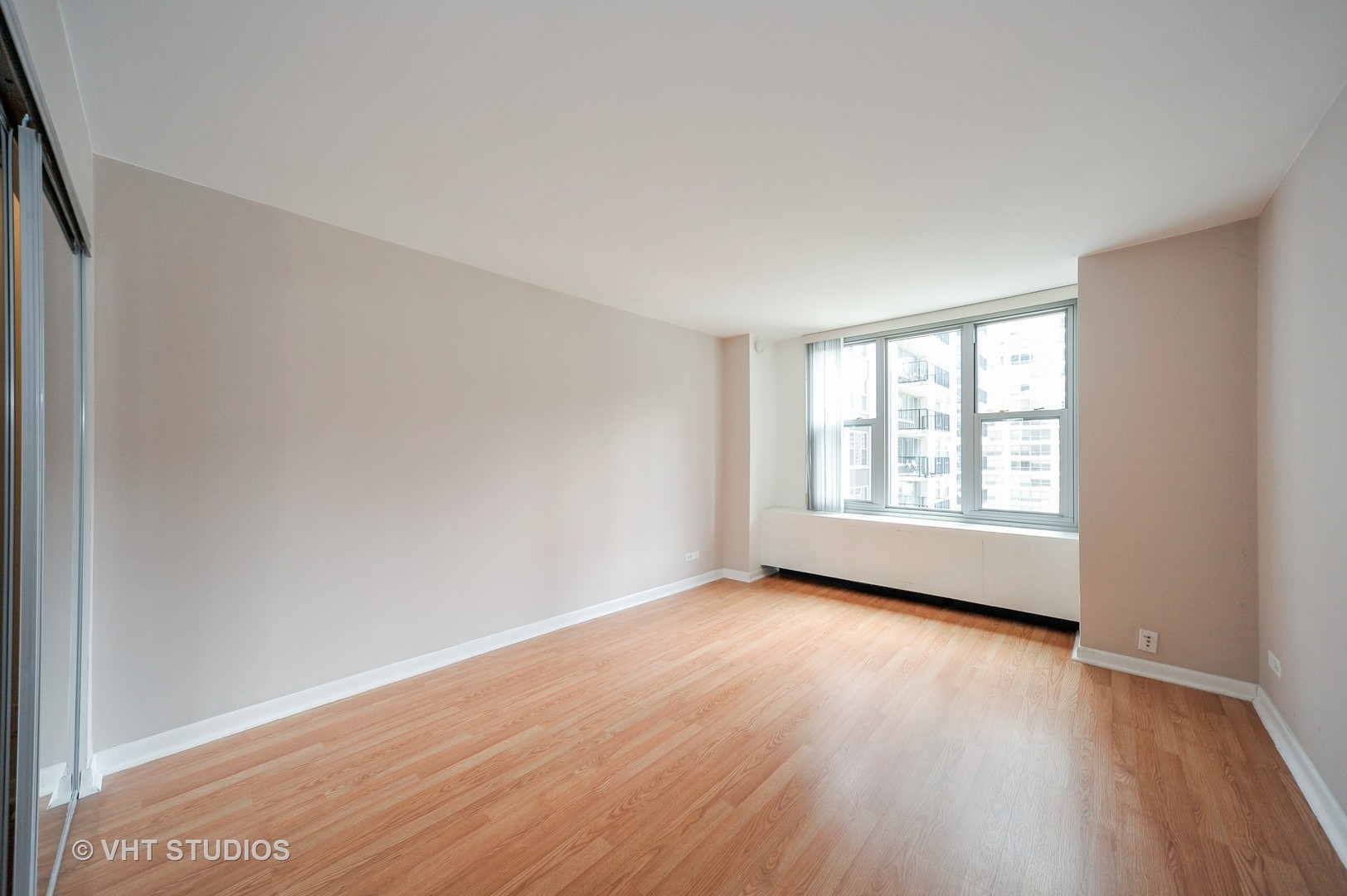 400 East Randolph Street, Unit 1924 Chicago, IL 60601 - Photo 6 of 18 an empty room with wooden floor and windows