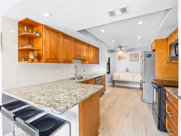 a kitchen with stainless steel appliances granite countertop sink stove and refrigerator