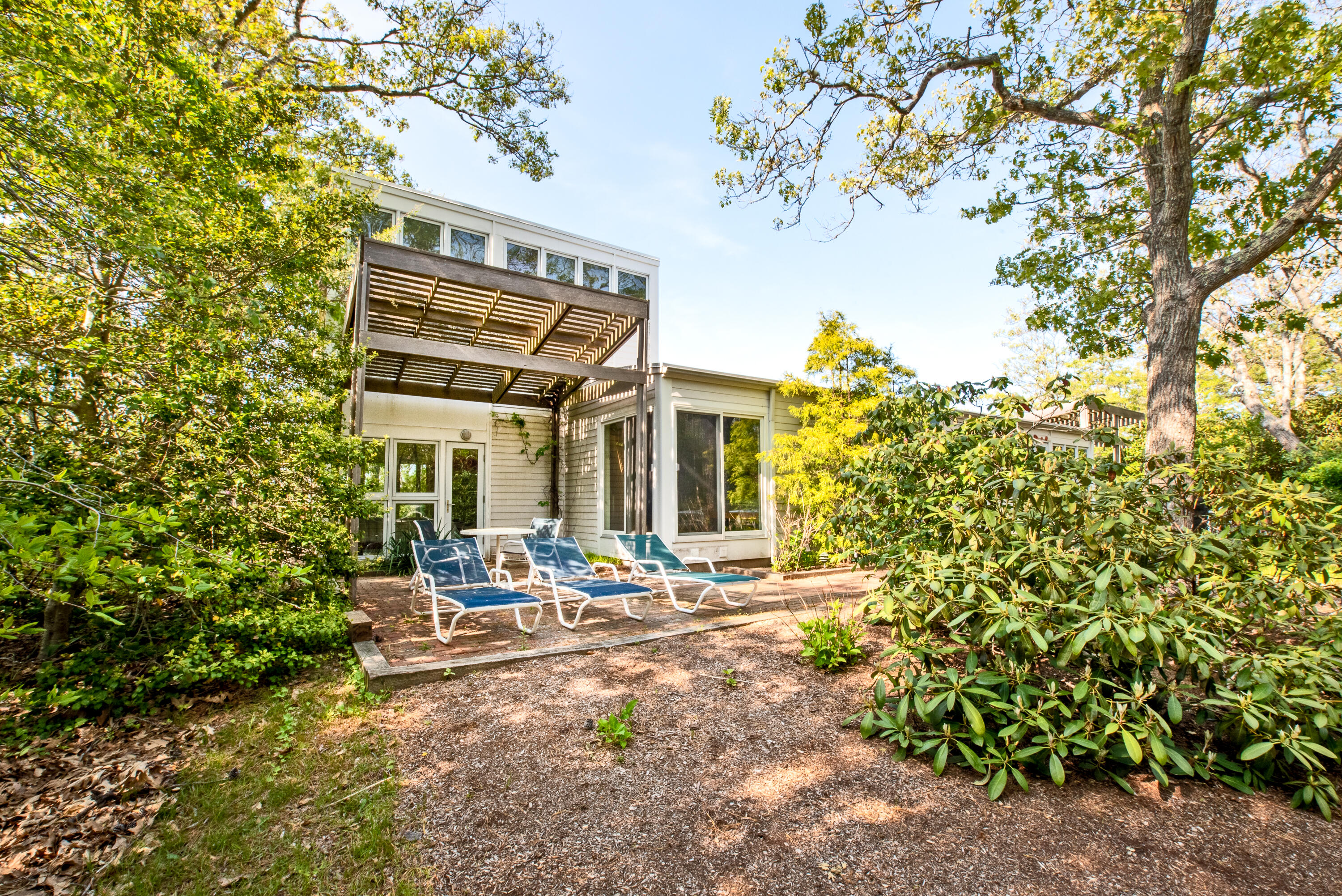 30 Gulch Road Wellfleet, MA 02667 - Photo 10 of 41 a backyard of a house with table and chairs and potted plants