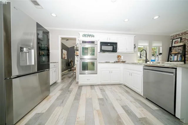 a kitchen with a sink stainless steel appliances and cabinets