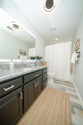 a spacious bathroom with a granite countertop sink and a mirror