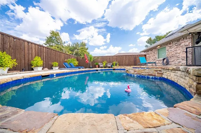 a view of swimming pool with seating space and wooden fence