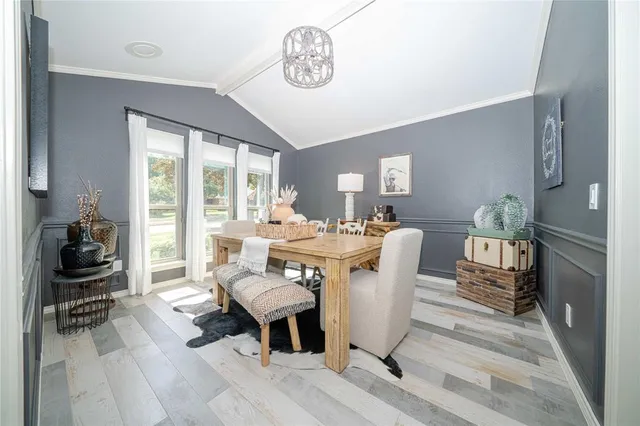 a dining room with wooden floor and a rug