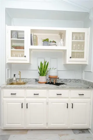 a sink with white cabinets and a window