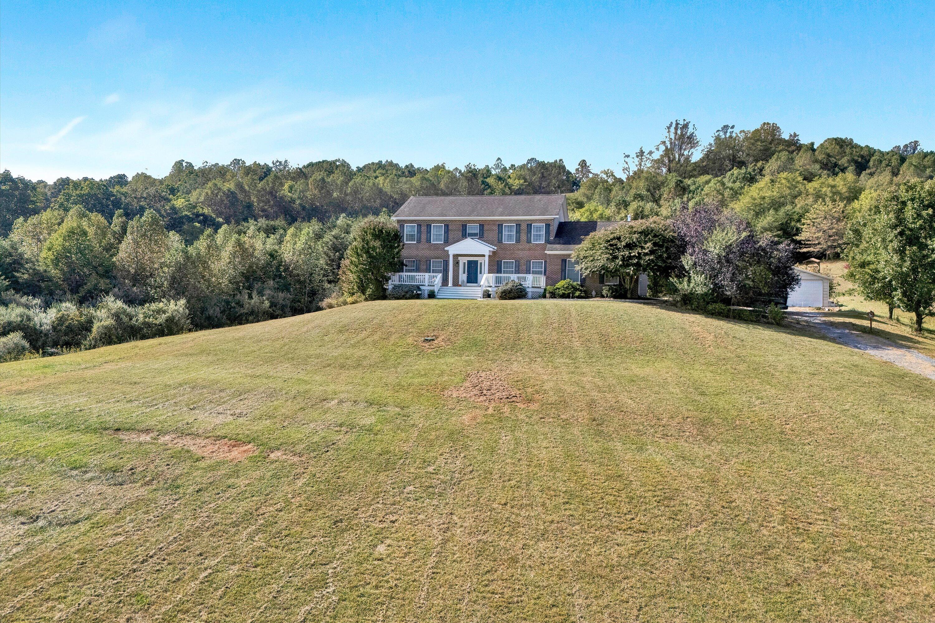 1670 Forge Road Lexington, VA 24450 - Photo 53 of 65 a front view of a house with a yard and mountain view in back
