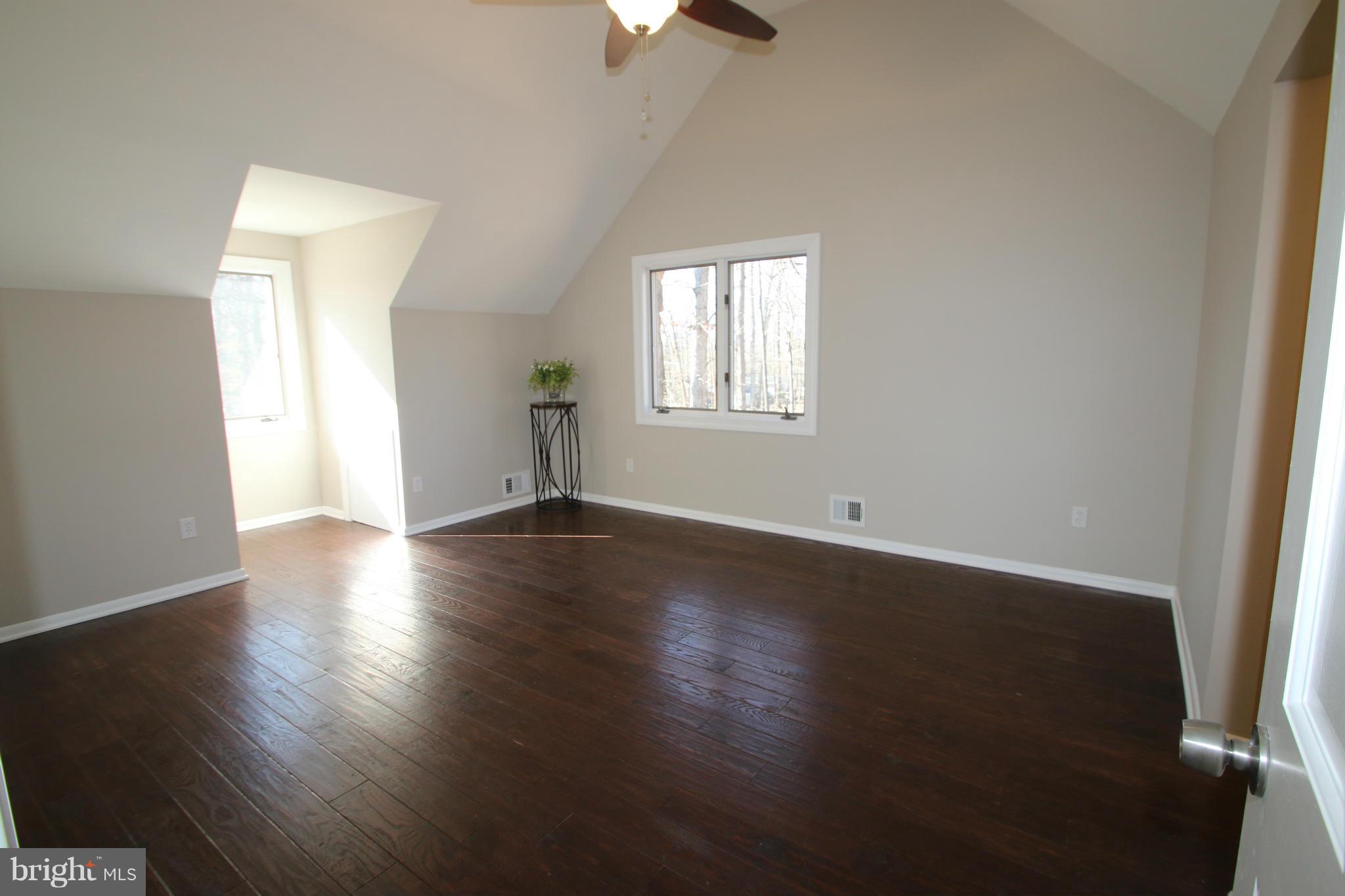 4321 Oaktree Road Rockville, MD 20853 - Photo 9 of 24 an empty room with wooden floor chandelier fan and windows