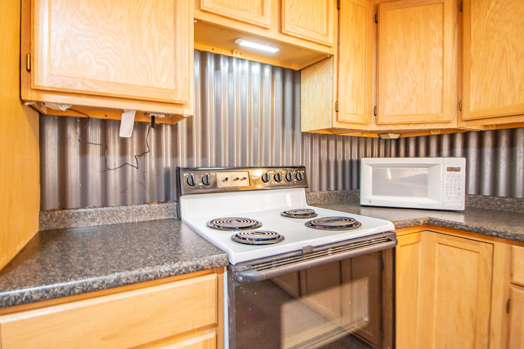 17 Eastwood Road Spur, TX 79370 - Photo 18 of 27 a kitchen with granite countertop cabinets washer and dryer