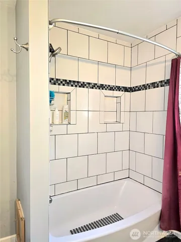 a bathroom with a bathtub and shower