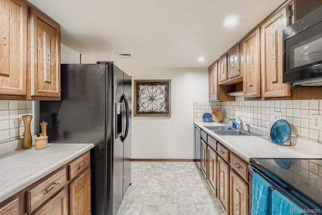 a kitchen with stainless steel appliances granite countertop a refrigerator a sink a stove and a microwave