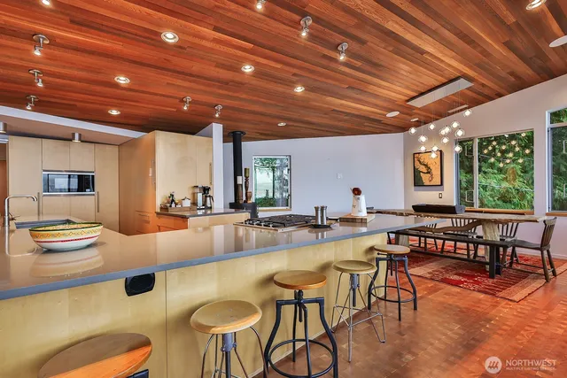 a room with furniture pool table and large windows