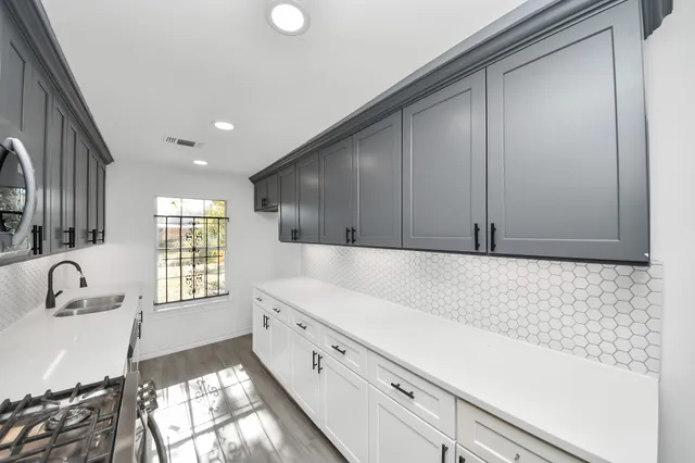 a kitchen with granite countertop white cabinets and window