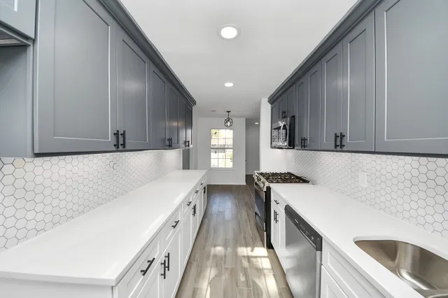 a kitchen with a sink a stove and a refrigerator
