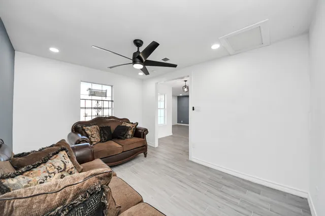a living room with furniture and a wooden floor