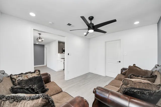 a living room with furniture and a wooden floor