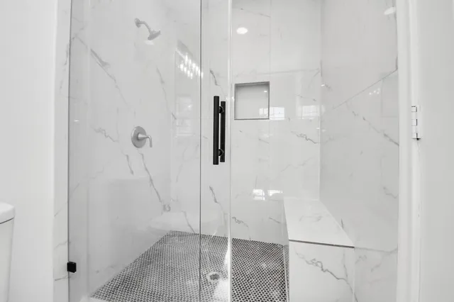 a bathroom with a shower and mirror