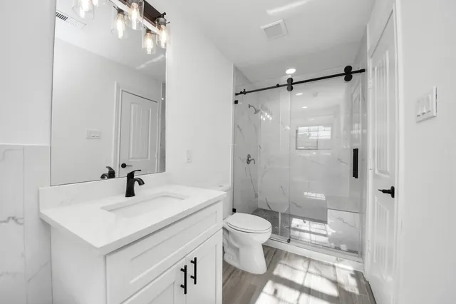 a bathroom with a sink toilet a mirror and shower