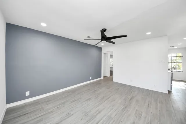 a view of a big room with wooden floor and windows