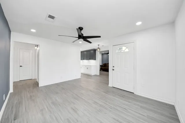 a view of empty room with wooden floor and window