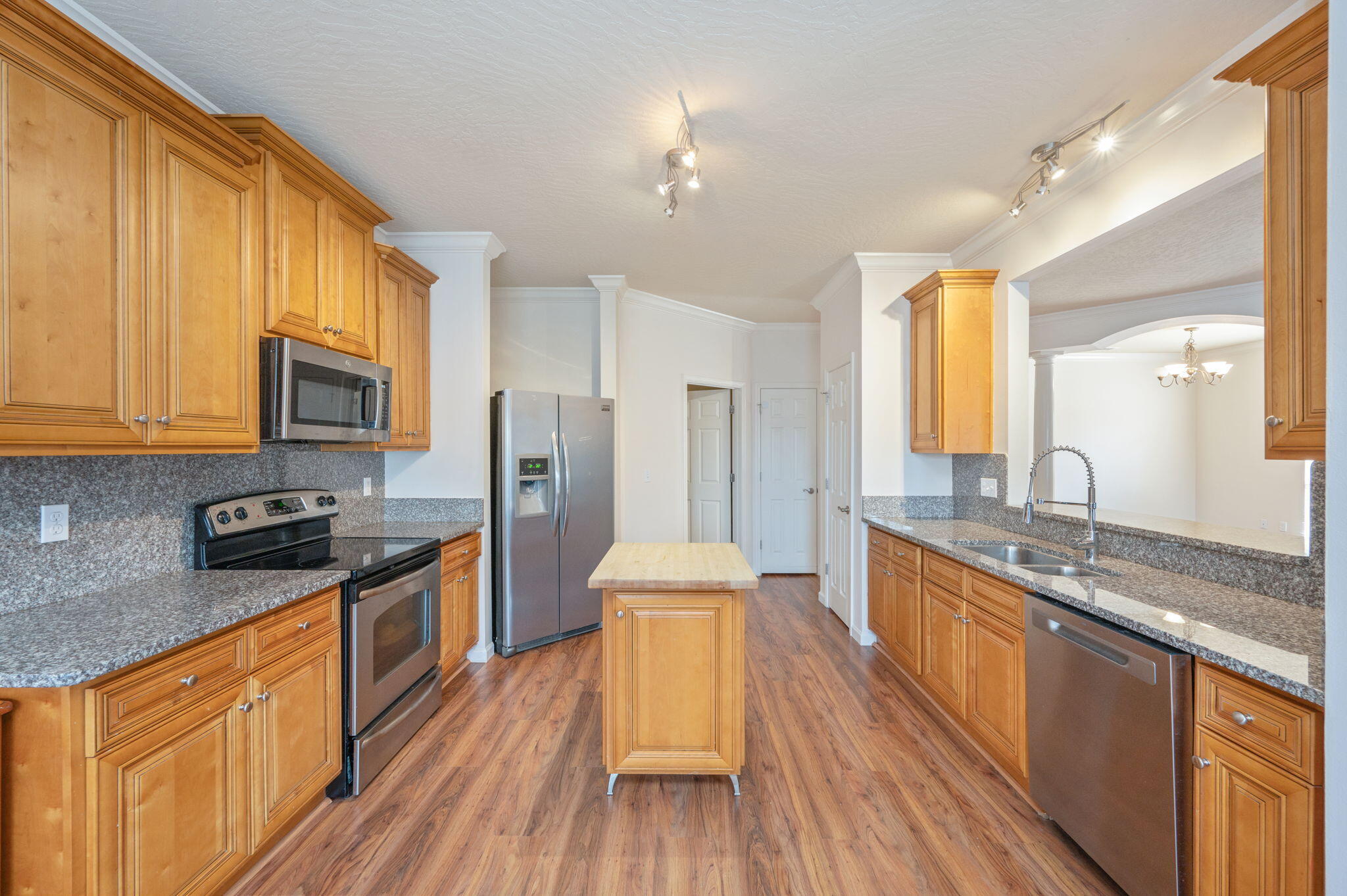 4627 Hermosa Road Crestview, FL 32539 - Photo 15 of 40 a large kitchen with stainless steel appliances granite countertop a stove a sink dishwasher and a refrigerator with wooden floor