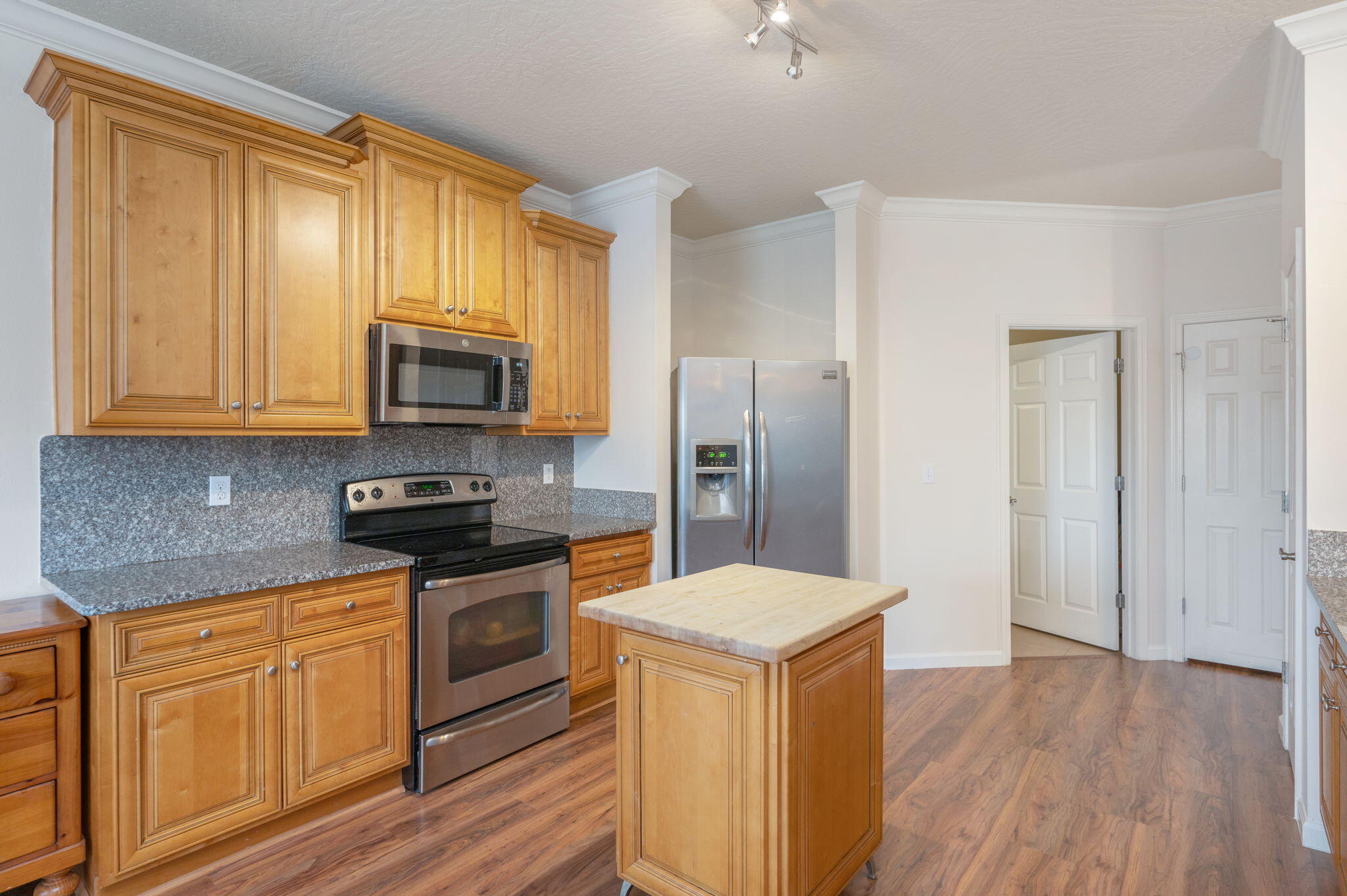 4627 Hermosa Road Crestview, FL 32539 - Photo 16 of 40 a kitchen with stainless steel appliances granite countertop a refrigerator a stove top oven a sink and dishwasher with wooden floor