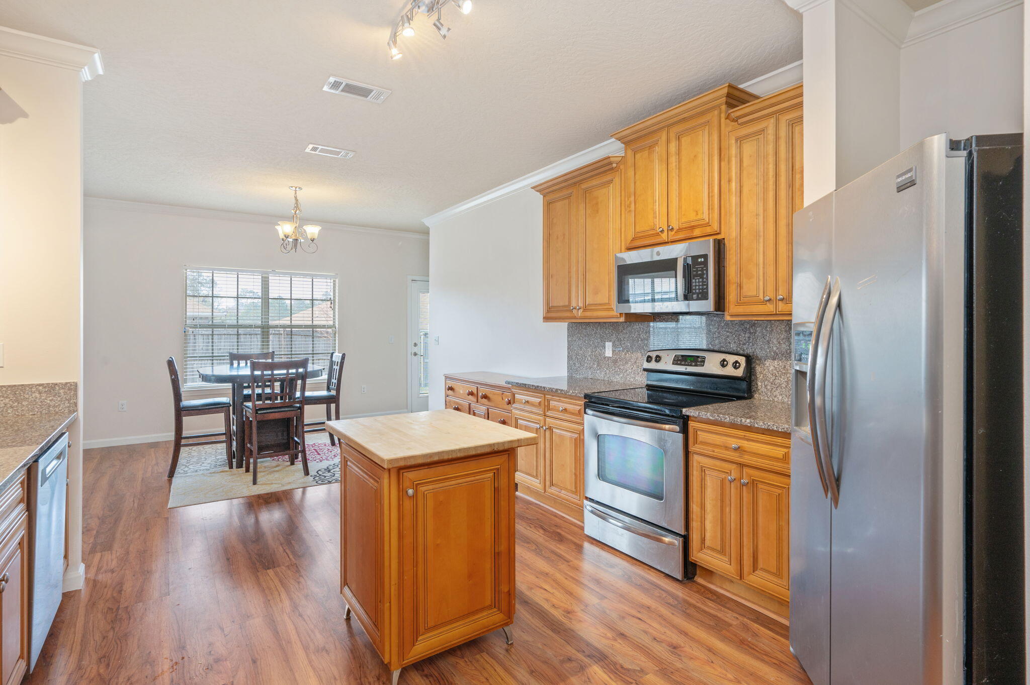 4627 Hermosa Road Crestview, FL 32539 - Photo 18 of 40 a kitchen with stainless steel appliances granite countertop a refrigerator stove microwave and wooden floor