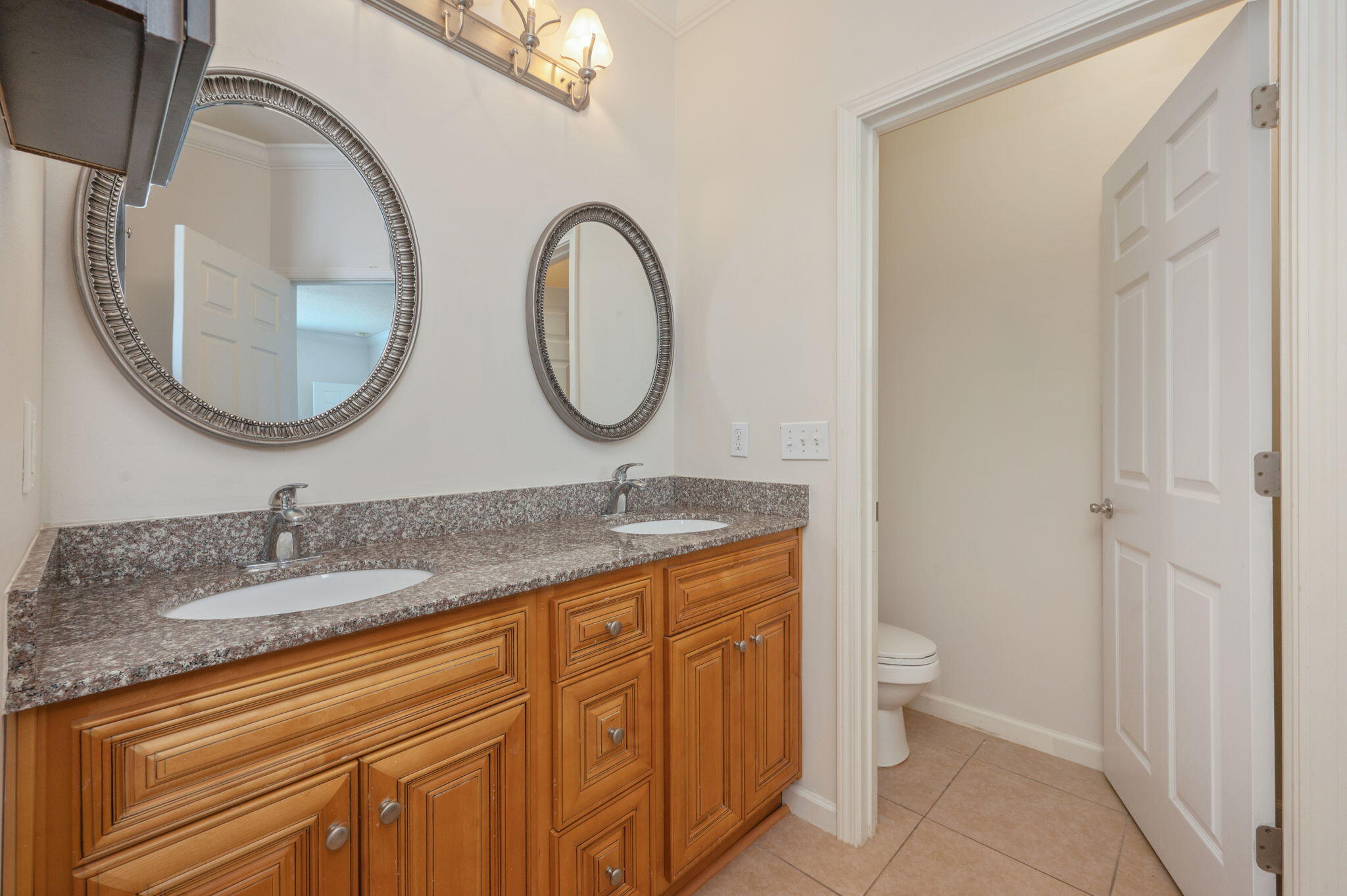 4627 Hermosa Road Crestview, FL 32539 - Photo 23 of 40 a bathroom with a granite countertop toilet a sink and a mirror