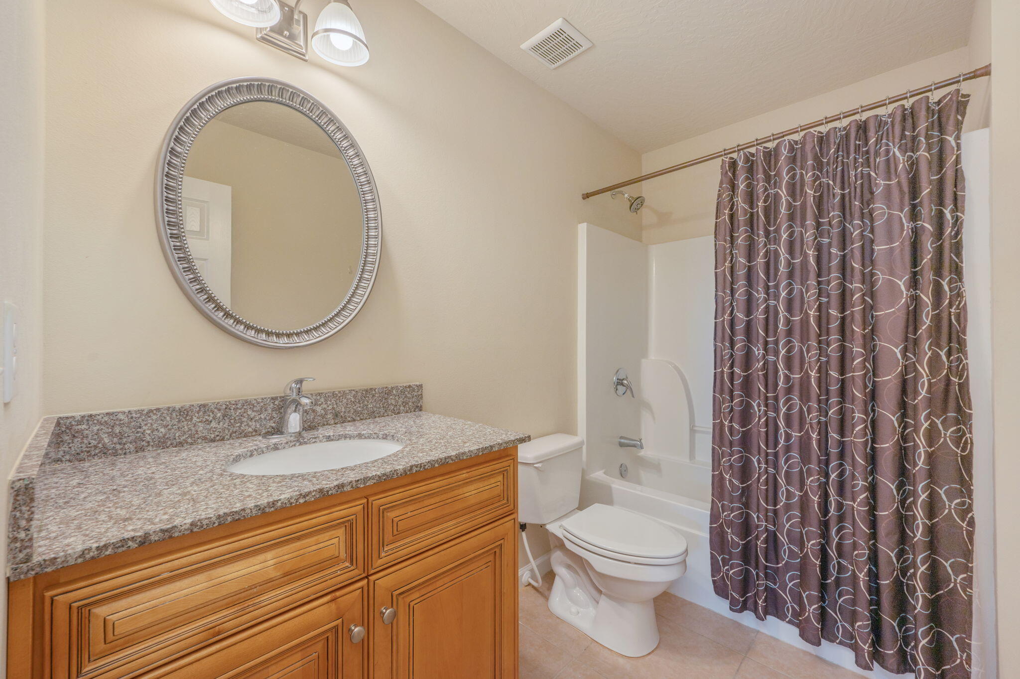 4627 Hermosa Road Crestview, FL 32539 - Photo 33 of 40 a bathroom with a granite countertop toilet a sink and a mirror