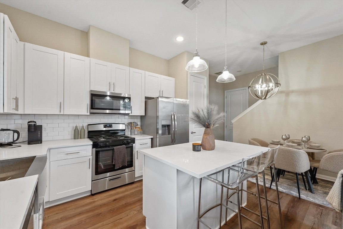 5620 Madison Street Houston, TX 77091 - Photo 5 of 17 a kitchen with stainless steel appliances a table chairs microwave and cabinets