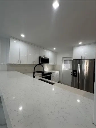 a view of a kitchen with a sink and a refrigerator
