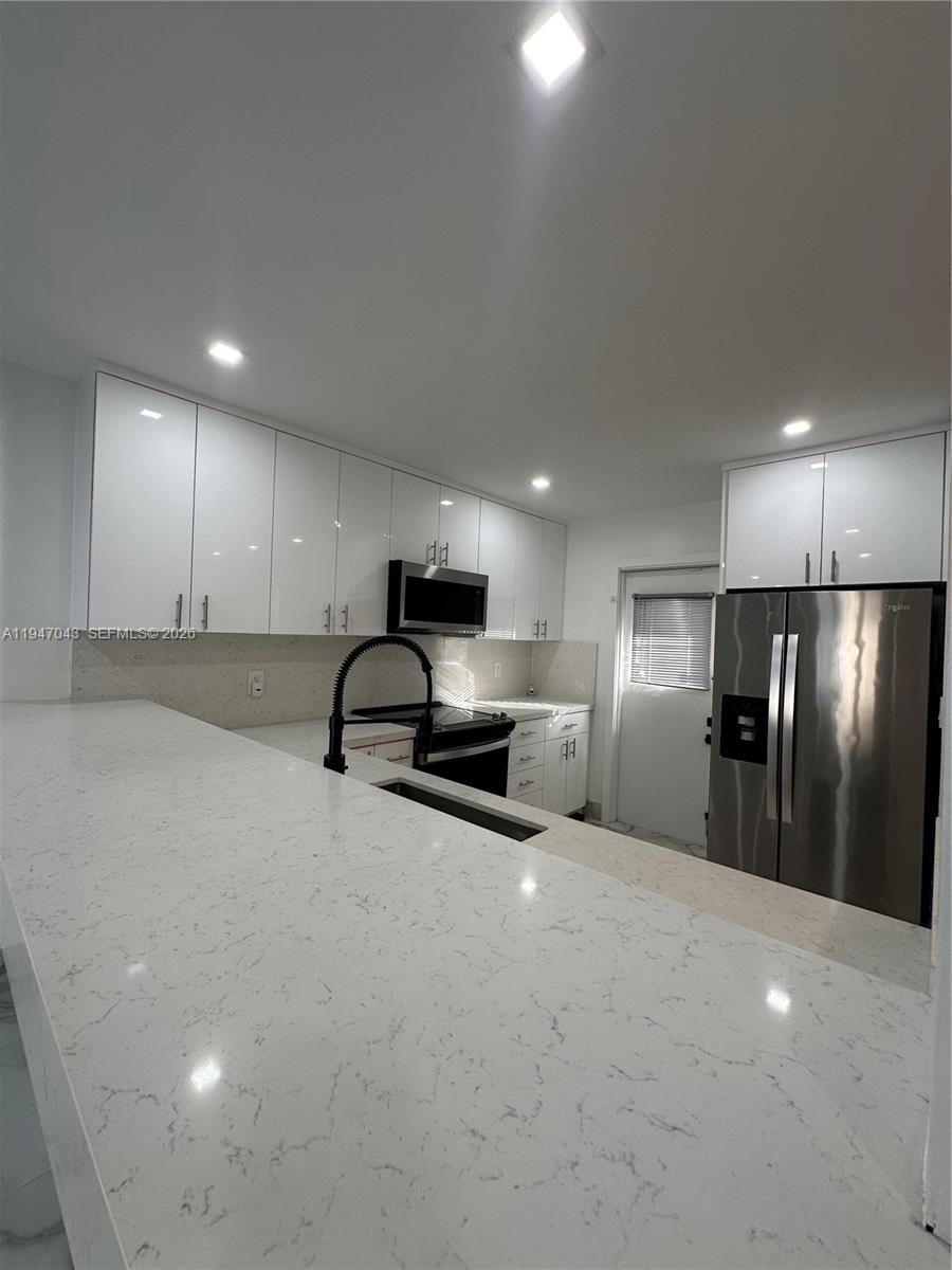 4100 North 58th Avenue, Unit 211 Hollywood, FL 33021 - Photo 11 of 47 a view of a kitchen with a sink and a refrigerator