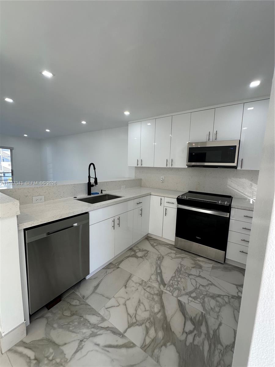 4100 North 58th Avenue, Unit 211 Hollywood, FL 33021 - Photo 2 of 47 a kitchen with a sink stove and microwave