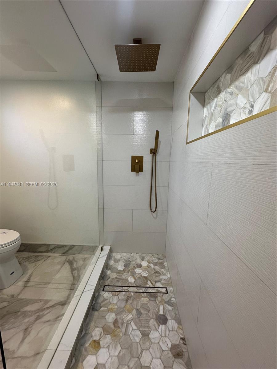 4100 North 58th Avenue, Unit 211 Hollywood, FL 33021 - Photo 31 of 47 a bathroom with a granite countertop shower and a toilet