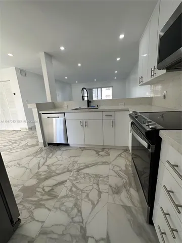 a kitchen with a sink stainless steel appliances and cabinets