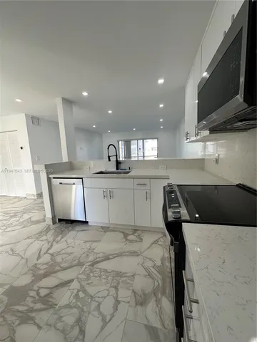 a kitchen with a sink stainless steel appliances and cabinets