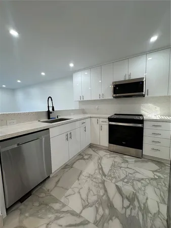 a kitchen with stainless steel appliances granite countertop a sink a stove a microwave and cabinets